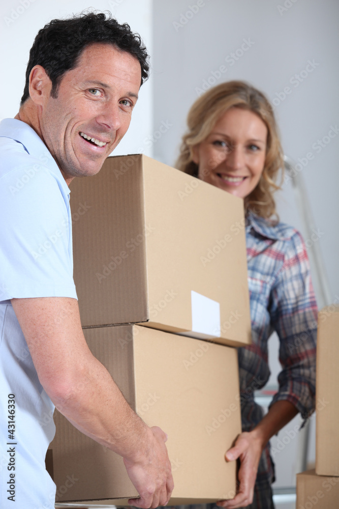 Couple moving pile of boxes Couple moving pile of boxes