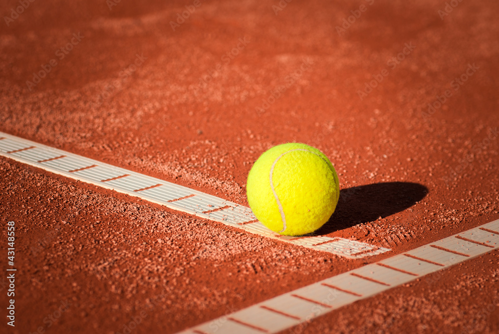 closeup on tennis ball on clay court