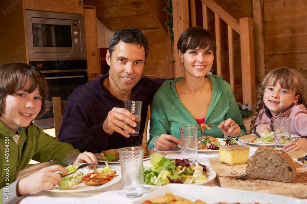 Family Enjoying Meal In Alpine Chalet Together