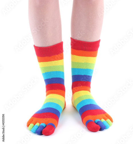female legs in colorful striped socks isolated on white