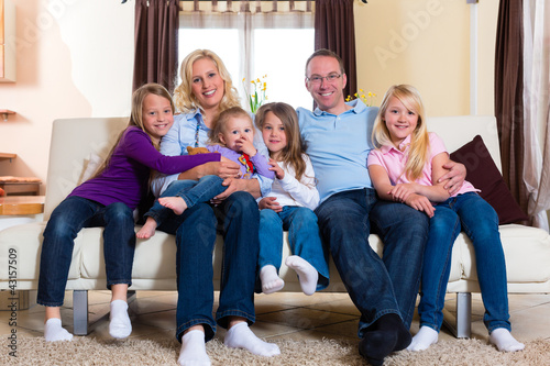 Familie auf der Couch daheim im Wohnzimmer