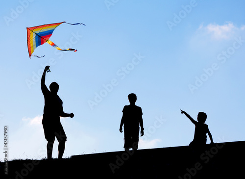 Launching a kite in the sky. Silhouettes man and two children.