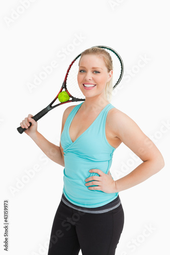 Woman smiling while holding a racquet behind her head © WavebreakmediaMicro