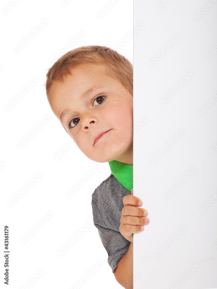 Kleiner Junge schaut hinter weißer Wand hervor Kleiner Junge schaut hinter weißer Wand hervor