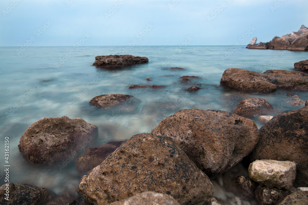 The coast of the blue sea with boulders