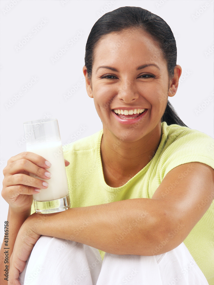 Joven mujer latina bebiendo un vaso de leche. Joven mujer latina bebiendo un vaso de leche.
