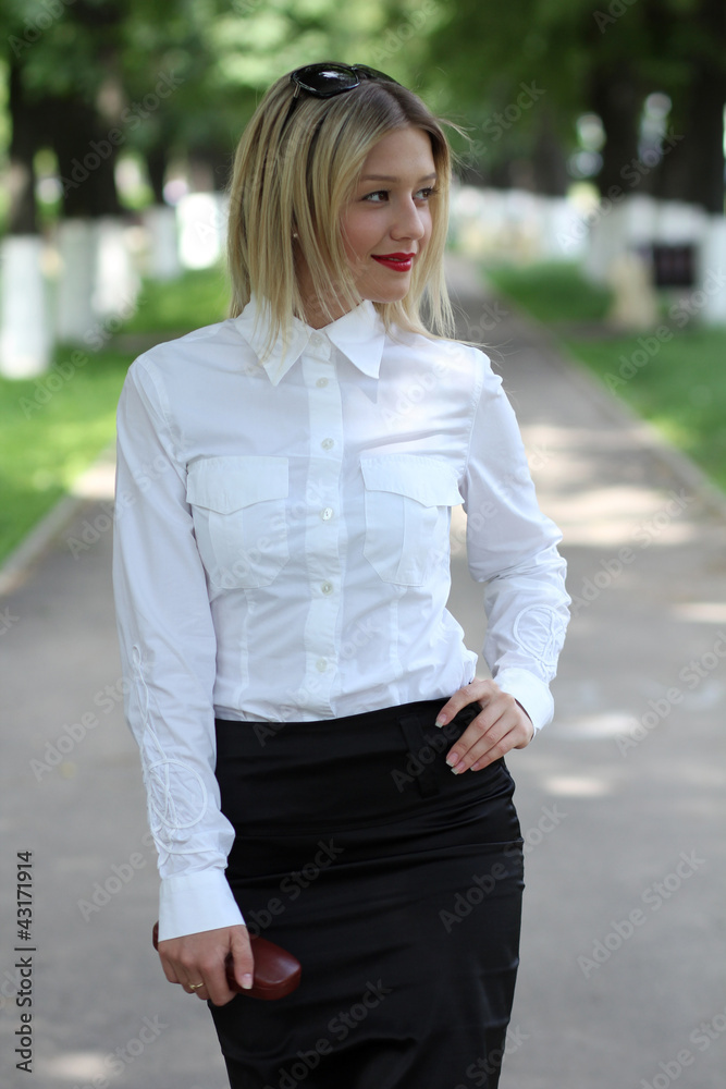 Portrait of young businesswoman standing in sunny park Portrait of young businesswoman standing in sunny park