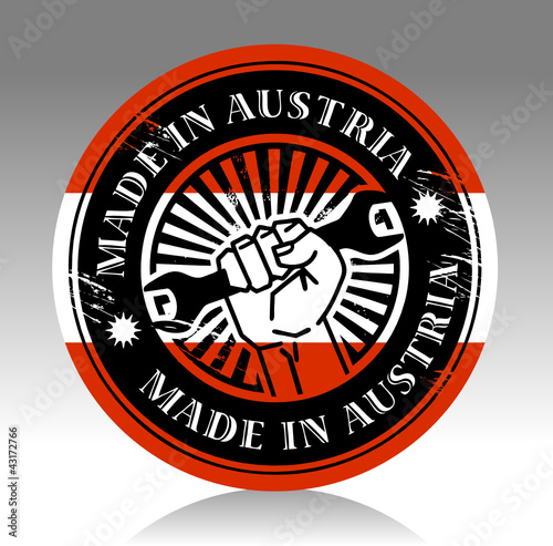Label with hand holding wrench and words made in austria, vector