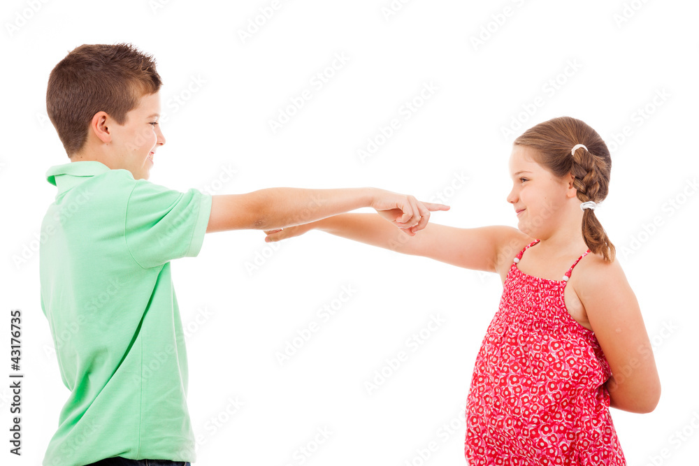 Two smiling children pointing each other, isolated on white back Two smiling children pointing each other, isolated on white back