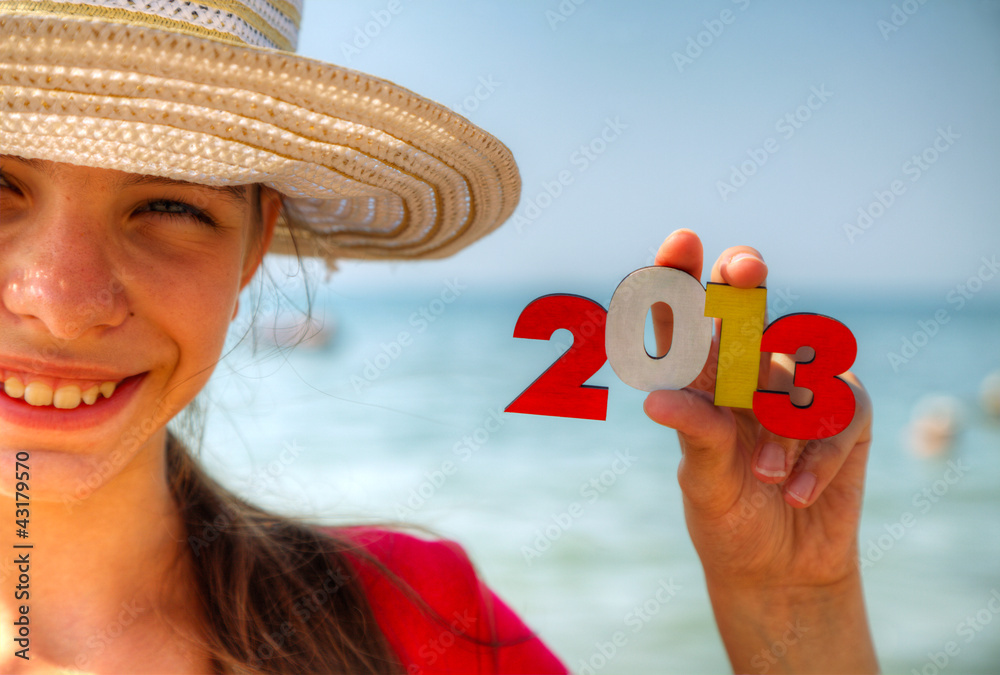 Teen girl holding wooden number '2013'