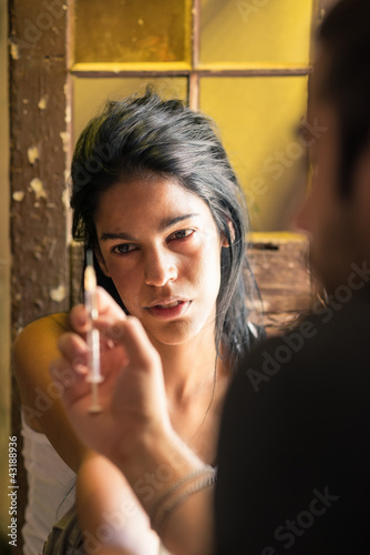 Drugs and people, man helping woman with heroin syringe