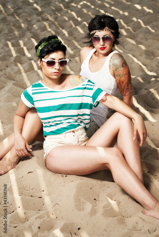 Fototapeta premium two adorable women with tattoos wearing sunglasses
