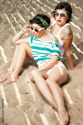 two adorable women with tattoos wearing sunglasses