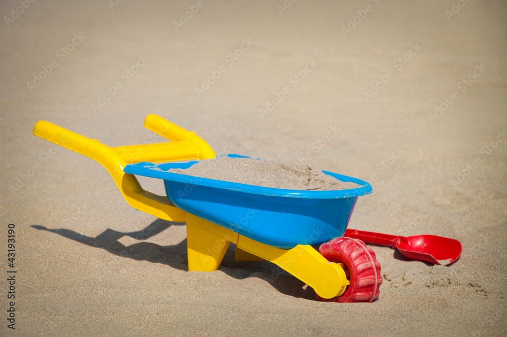 Plastic toys in the sand at the empty beach Plastic toys in the sand at the empty beach
