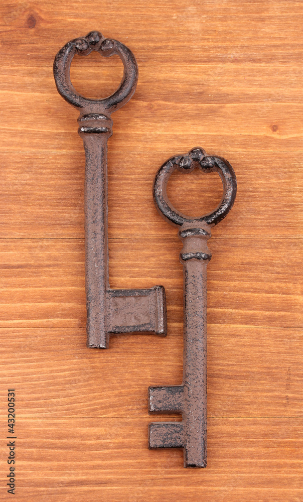 Two antique keys on wooden background Two antique keys on wooden background