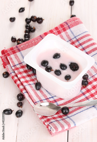 Yogurt with berries on wooden background