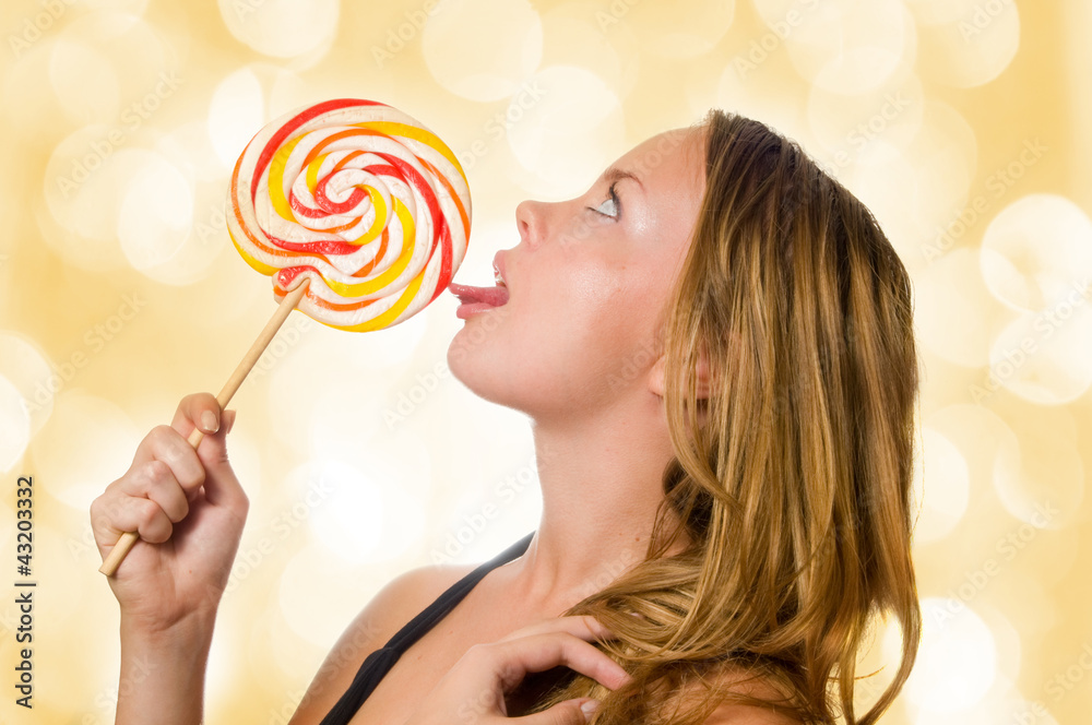 Woman licking sweet sugar candy closeup.
