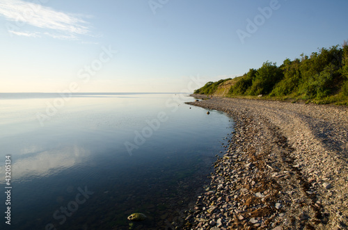 Fototapeta Naklejka Na Ścianę i Meble -  Stony coastline a calm and bright summer evening