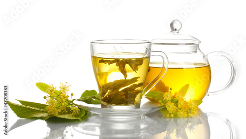 cup and teapot of linden tea and flowers isolated on white