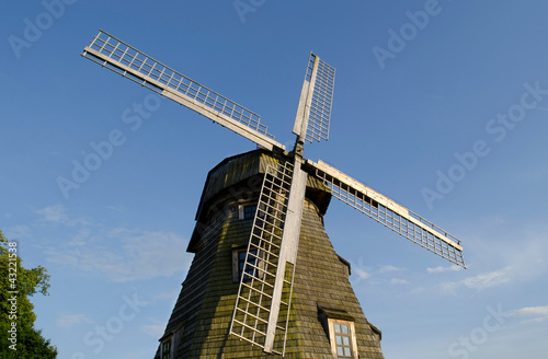 Retro wooden mill wings against blue sky