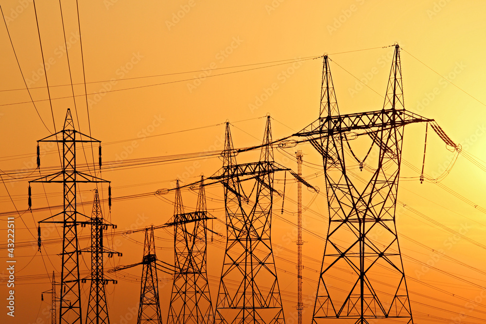 high voltage electrical pylons during sunset