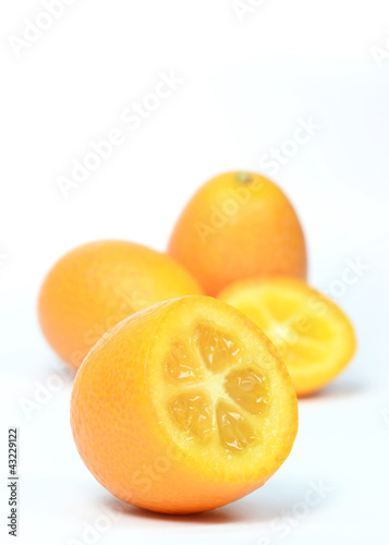 Group of sliced and whole kumquats on white background