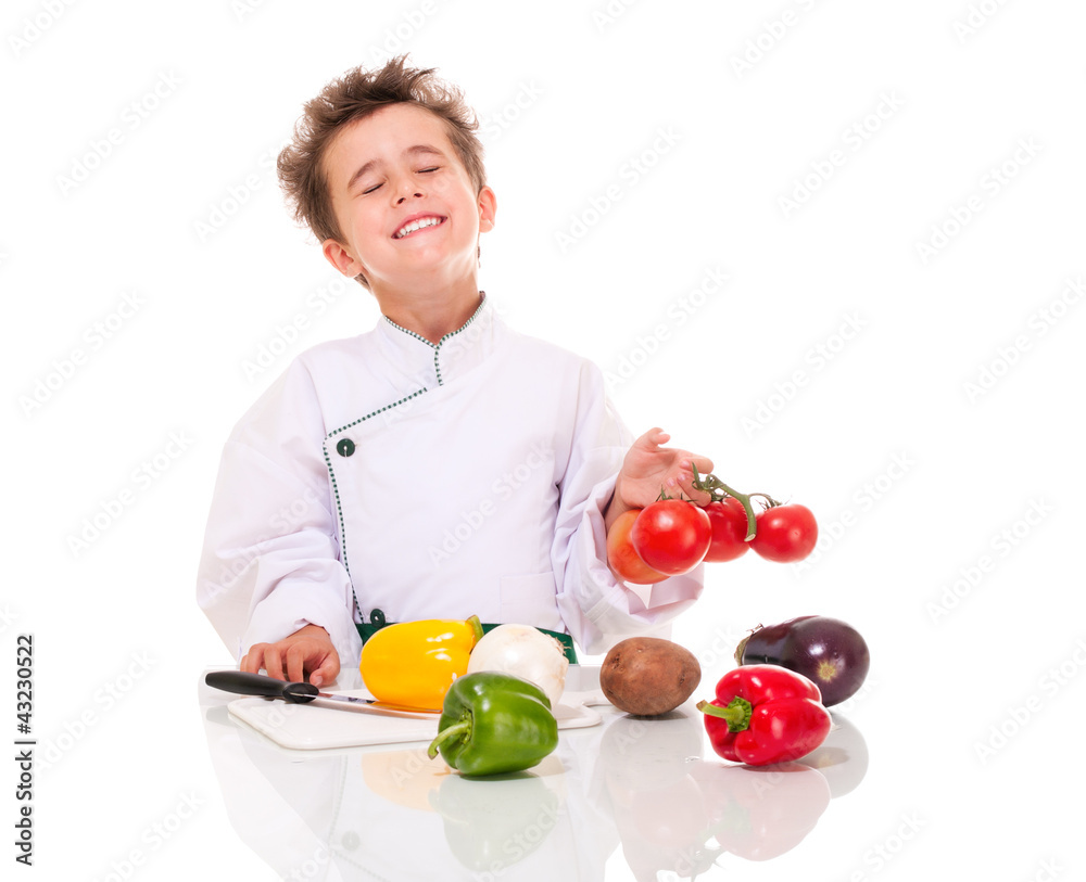 Little boy chef in uniform with knife cooking vegatables holding Little boy chef in uniform with knife cooking vegatables holding