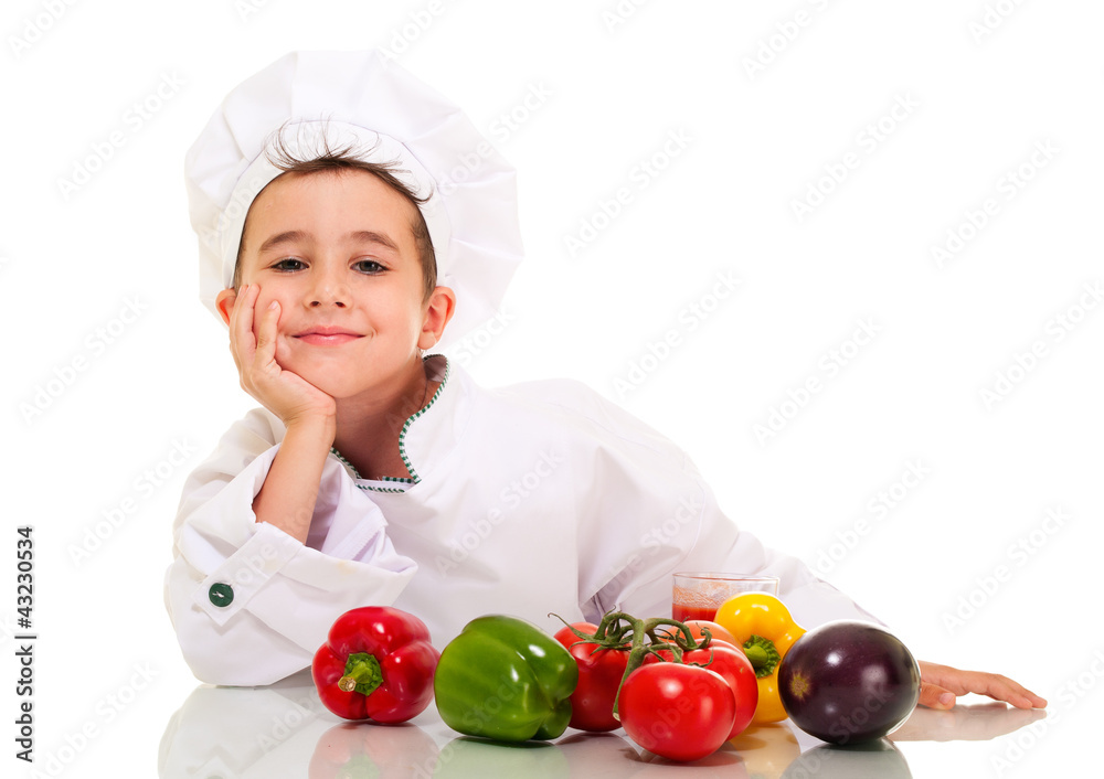 Little happy boy chef in uniform with vegatables lean on hand Little happy boy chef in uniform with vegatables lean on hand