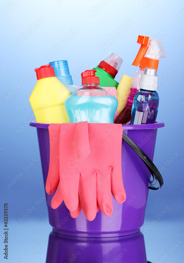 Bucket with cleaning items on blue background Bucket with cleaning items on blue background