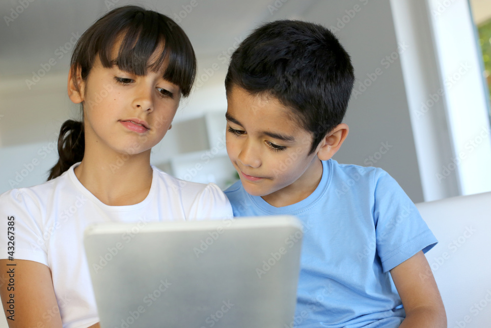 Children playing with electronic tablet at home Children playing with electronic tablet at home