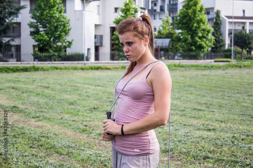 Sensual and tired girl keep fit in a urban landscape