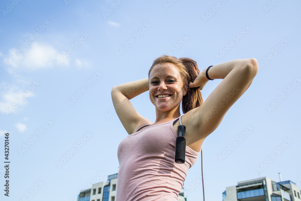 Sensual and smiling girl keep fit in a urban landscape