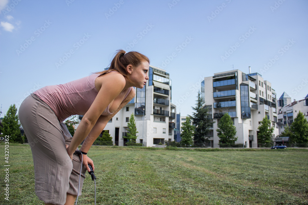 Sensual and tired girl keep fit in a urban landscape