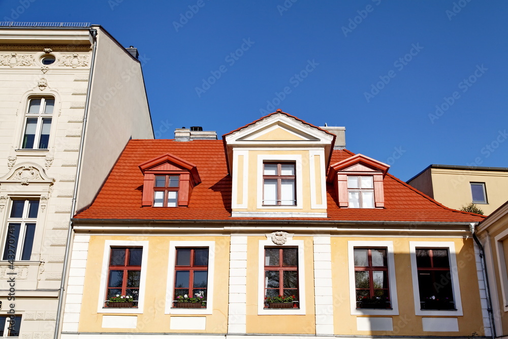 Maison au toit rouge, ciel bleu.