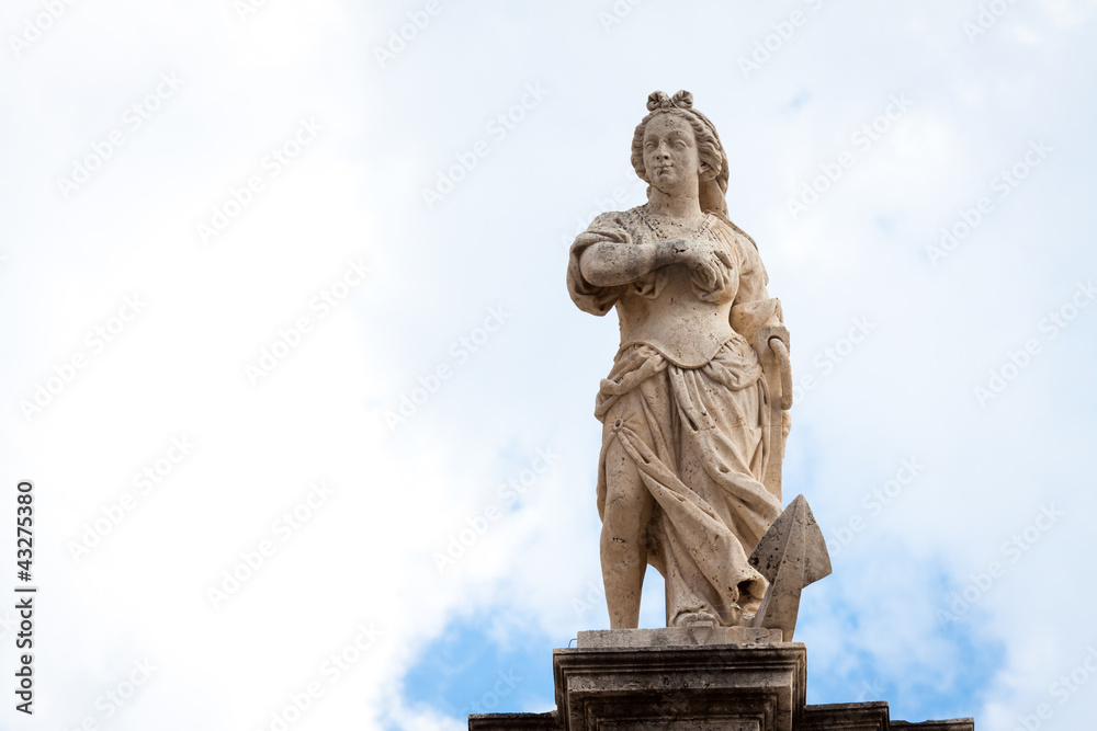 Woman rising above an anchor statue on top of St. Blaise church