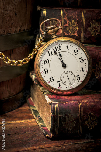 Old pocket watch and books in Low-key