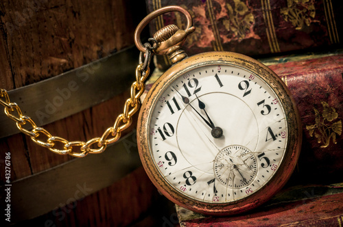 Old pocket watch and books in Low-key