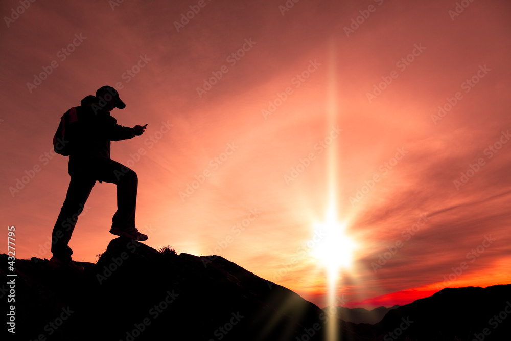 young man using smart phone on the top of mountain