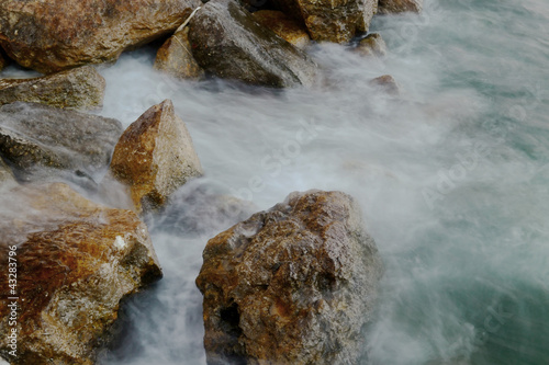 Rocks in the water. Waves Motion blur by long exposure.