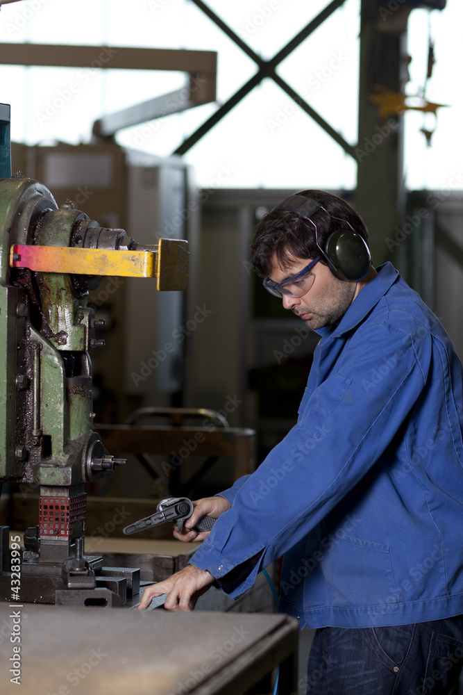 Arbeiter an Maschine in Fabrikhalle Arbeiter an Maschine in Fabrikhalle