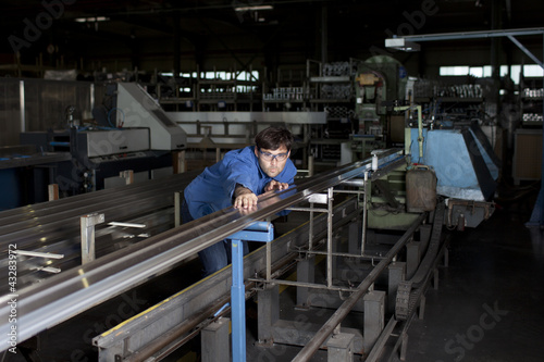 Blue collar worker at machine in factory