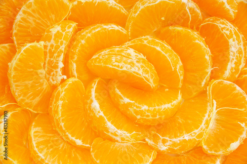 Many orange segments all laid out as a background photo