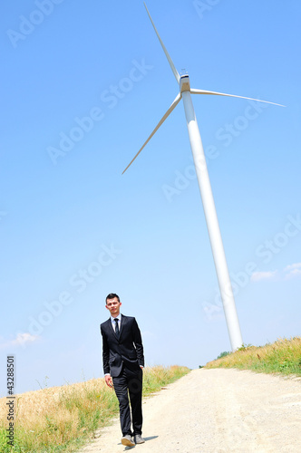 Business man near wind farm