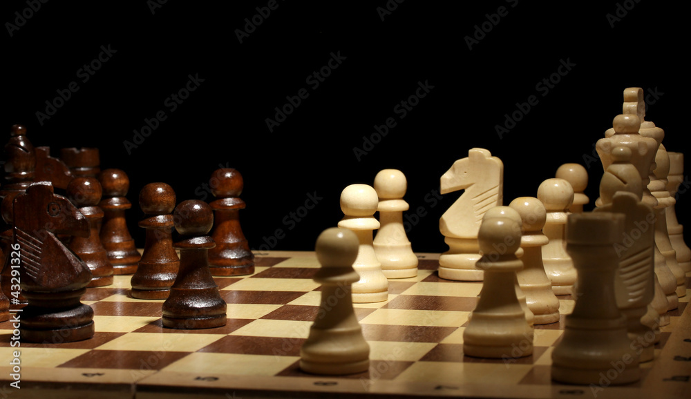 Chess board with chess pieces isolated on black Chess board with chess pieces isolated on black