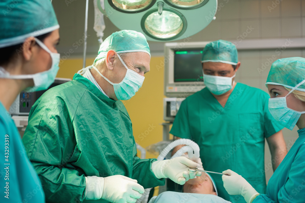 Smiling surgeon working with a team Smiling surgeon working with a team