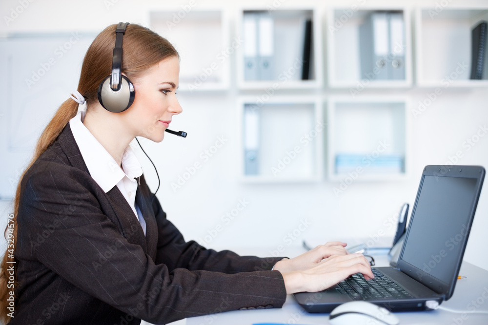 Portrait of pretty young female operator sitting at office desk Portrait of pretty young female operator sitting at office desk