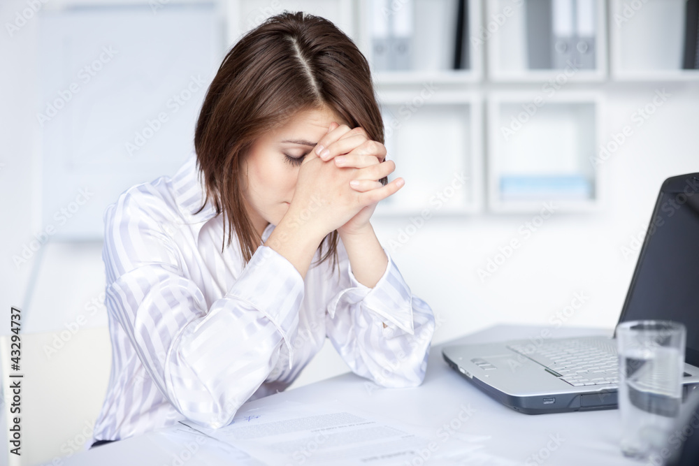 Tired young business woman in bright office Tired young business woman in bright office