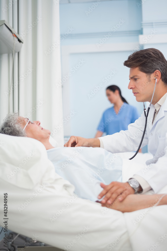 Fototapeta premium Doctor auscultating a patient with a stethoscope