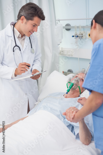 Doctor looking at patient next to a nurse