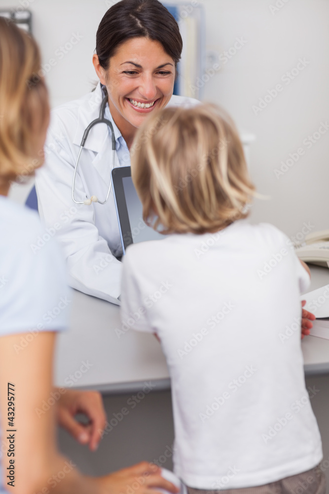 Smiling doctor presenting a tablet computer to a child Smiling doctor presenting a tablet computer to a child